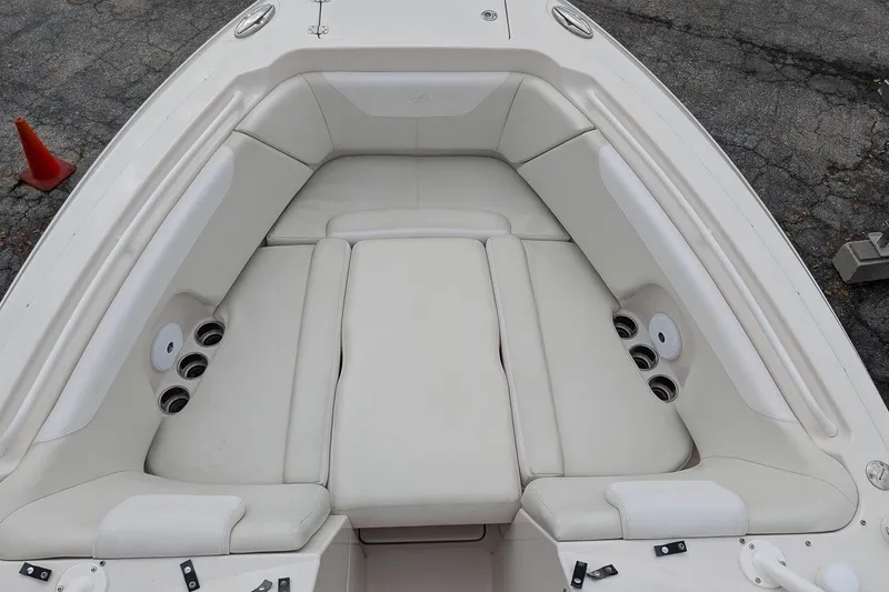 Slide: The Image of 2014 Sailfish 275 DC boat interior with white cushioned seating and cup holders. - 21