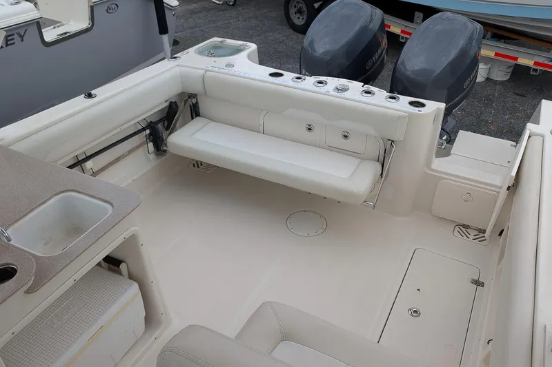 Slide: The Image of 2014 Sailfish 275 DC boat interior with seating, sink, and dual outboard motors. - 7