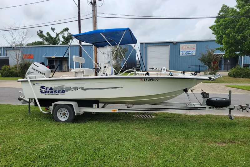 Slide: The Image of 2004 Sea Chaser 1950 RG boat on trailer with Honda motor, parked outdoors. - 15