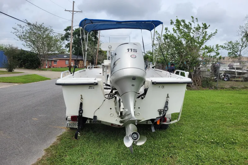 Slide: The Image of 2004 Sea Chaser 1950 RG boat with 115 HP outboard motor, parked on grass. - 16