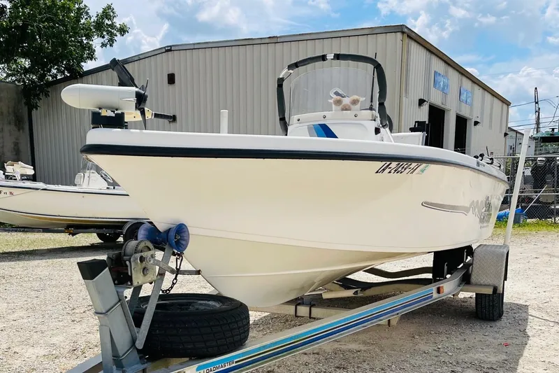 Slide: The Image of 2004 Sea Chaser 1950 RG boat on trailer, parked outdoors near a warehouse. - 2