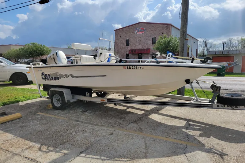 Slide: The Image of 2004 Sea Chaser 1950 RG boat on trailer, parked outdoors under cloudy sky. - 3