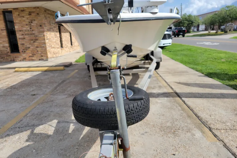 Slide: The Image of 2004 Sea Chaser 1950 RG boat on trailer, parked in a sunny urban area. - 4