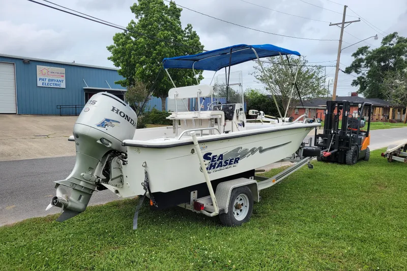 Slide: The Image of 2004 Sea Chaser 1950 RG boat with Honda motor on trailer, parked near a building. - 7