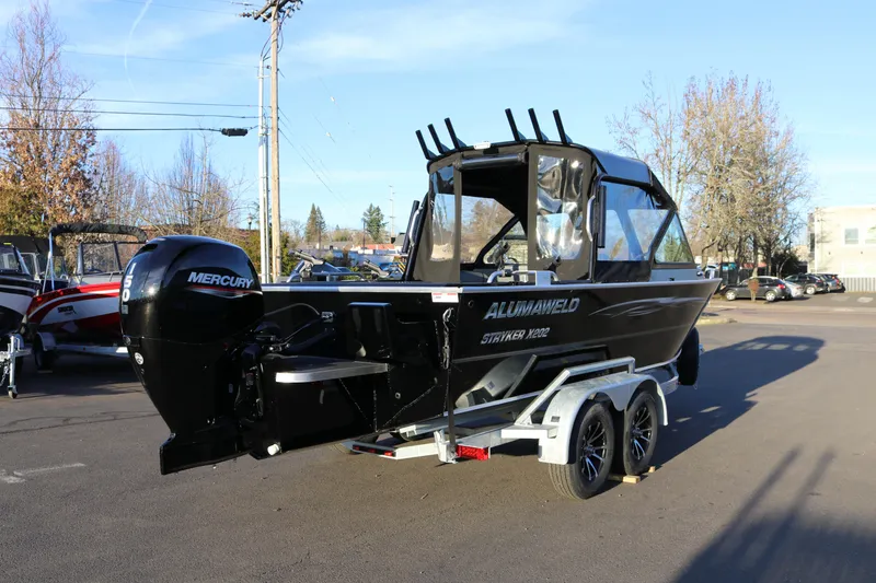 Slide: The Image of 2026 Alumaweld Stryker X202 boat with Mercury engine on trailer in parking lot. - 3