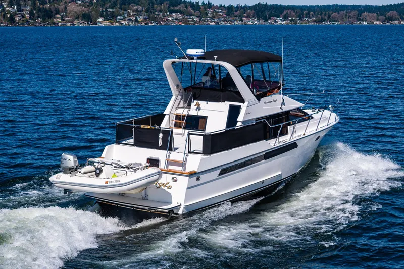 Slide: The Image of 1989 Ocean Alexander 42 yacht cruising on a scenic blue lake. - 11