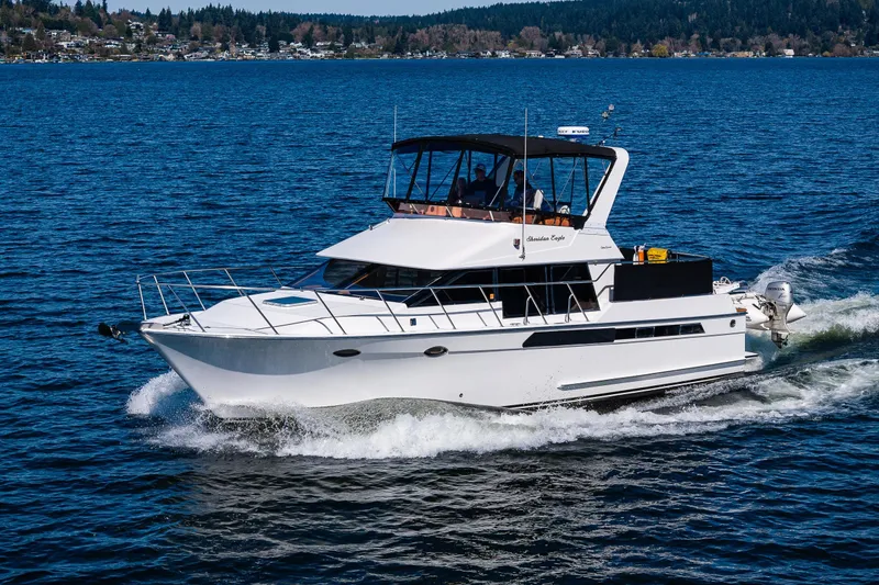 Slide: The Image of 1989 Ocean Alexander 42 yacht cruising on a scenic blue lake. - 12