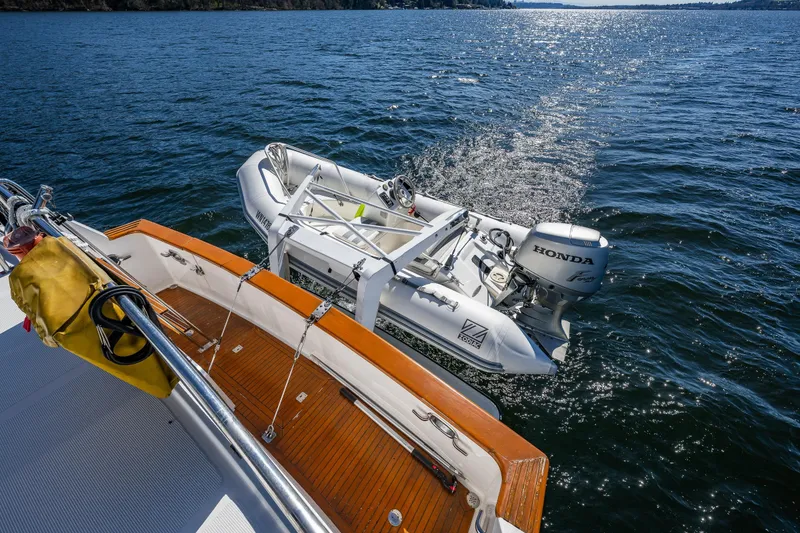 Slide: The Image of Ocean Alexander 42 yacht with a Honda-powered dinghy on the water, 1989 model. - 27