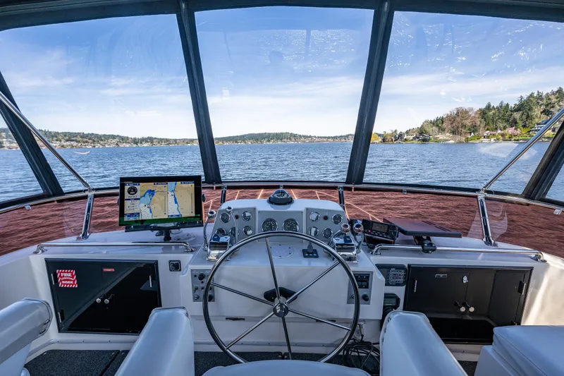 Slide: The Image of Cockpit view of 1989 Ocean Alexander 42 yacht with navigation equipment and scenic waterway. - 31