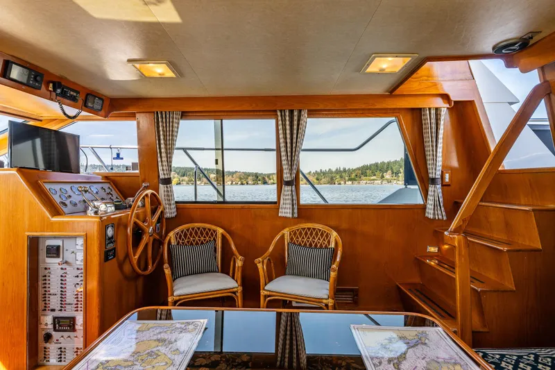 Slide: The Image of Interior of 1989 Ocean Alexander 42 yacht with wooden helm, seating, and scenic window view. - 43