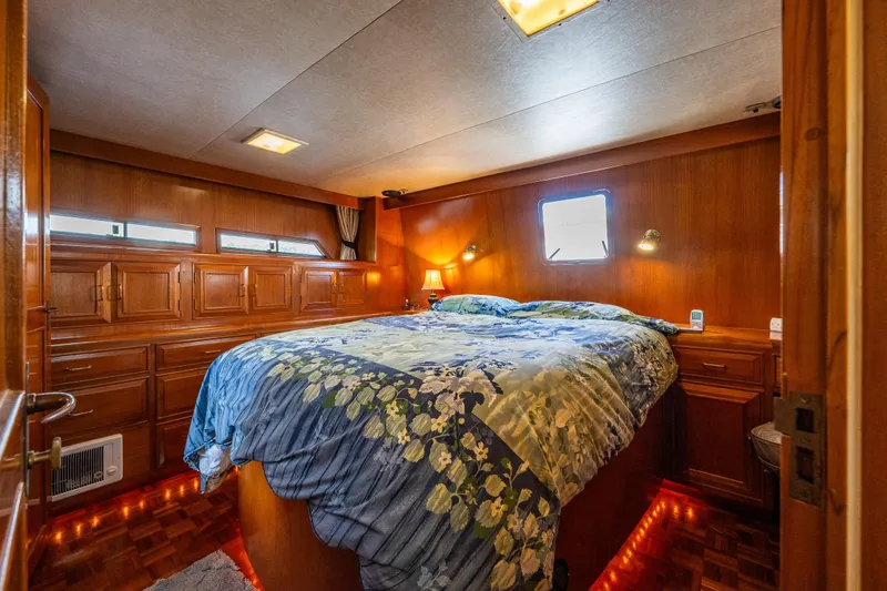 Slide: The Image of Luxurious 1989 Ocean Alexander 42 yacht bedroom with wood paneling and cozy bedding. - 47