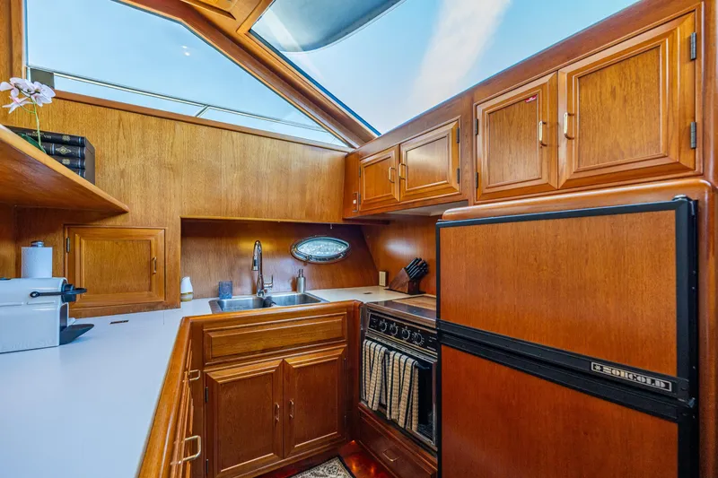 Slide: The Image of Luxurious 1989 Ocean Alexander 42 yacht kitchen with wood cabinetry and modern appliances. - 49