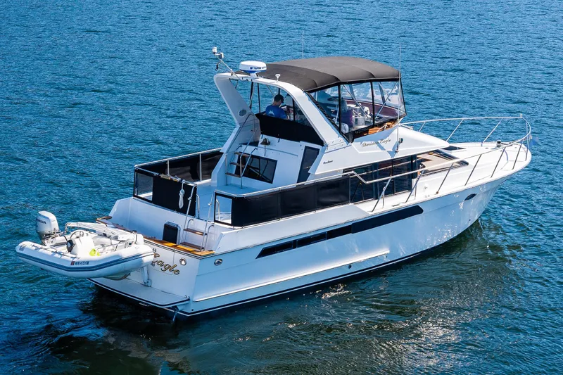 Slide: The Image of 1989 Ocean Alexander 42 yacht cruising on blue water, featuring sleek design and spacious deck. - 5