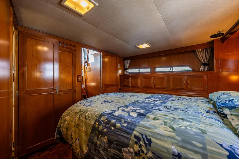 Slide: The Image of Luxurious cabin interior of 1989 Ocean Alexander 42 yacht with wood paneling and floral bedding. - 51
