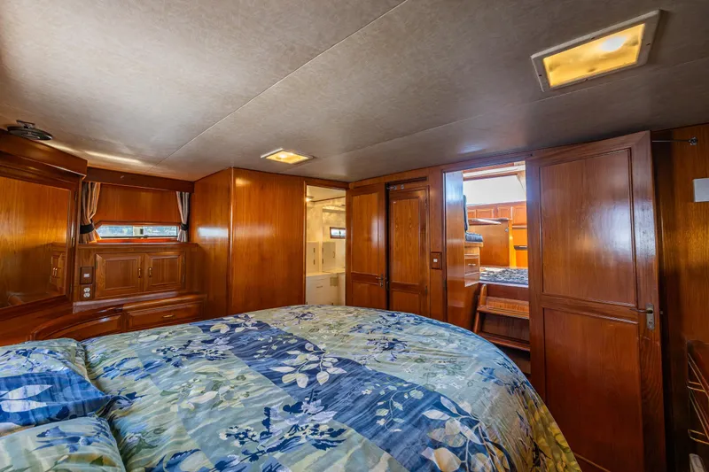 Slide: The Image of Luxurious 1989 Ocean Alexander 42 yacht bedroom with wood paneling and floral bedding. - 53