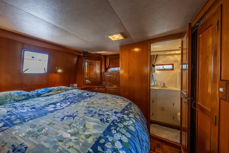 Slide: The Image of Luxurious 1989 Ocean Alexander 42 yacht bedroom with ensuite bathroom and elegant wood finishes. - 54