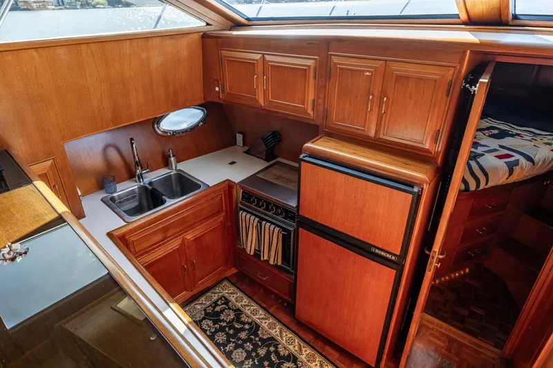 Slide: The Image of 1989 Ocean Alexander 42 yacht kitchen with wood cabinetry, sink, stove, and refrigerator. - 58