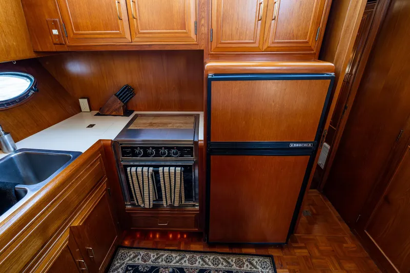 Slide: The Image of 1989 Ocean Alexander 42 yacht kitchen with wood cabinetry, stove, and refrigerator. - 60