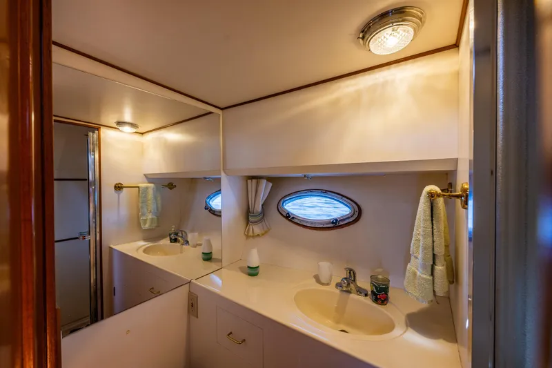 Slide: The Image of Luxurious bathroom interior of 1989 Ocean Alexander 42 yacht with dual sinks and porthole window. - 62