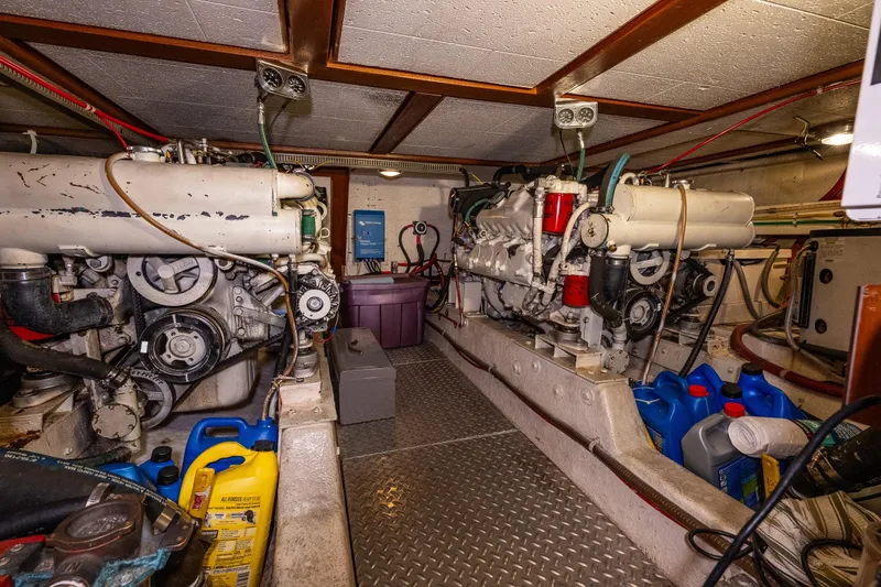 Slide: The Image of Engine room of 1989 Ocean Alexander 42 yacht, featuring dual engines and maintenance supplies. - 65
