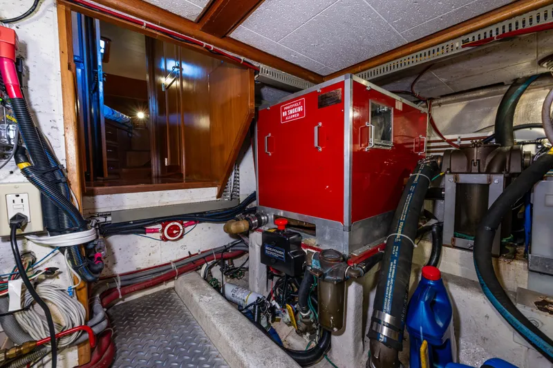 Slide: The Image of Engine room of 1989 Ocean Alexander 42 yacht with red machinery and wiring. - 66