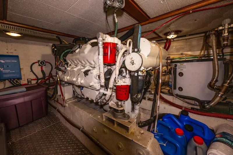 Slide: The Image of Engine room of 1989 Ocean Alexander 42 yacht, featuring mechanical components and storage containers. - 67