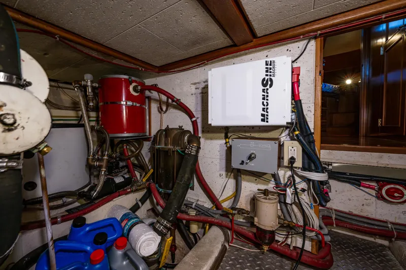 Slide: The Image of Engine room of 1989 Ocean Alexander 42 yacht, featuring mechanical equipment and wiring. - 68