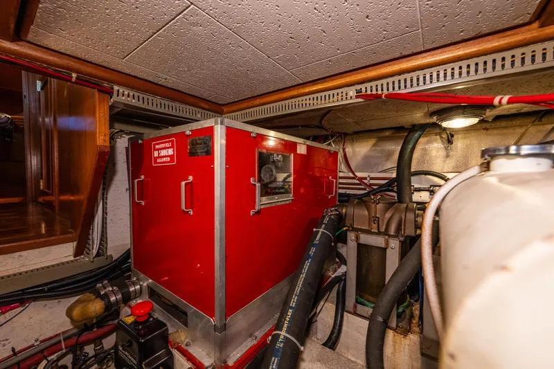 Slide: The Image of Engine room of 1989 Ocean Alexander 42 yacht with red machinery and piping. - 69