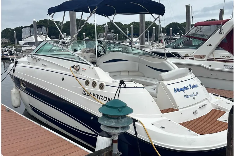 Slide: The Image of 2006 Glastron GS 269 boat docked at marina with canopy and seating area. - 3