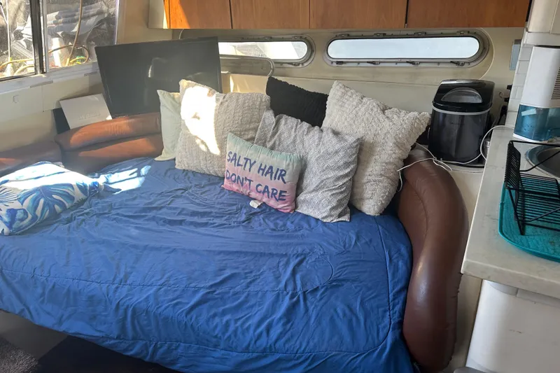 Slide: The Image of Interior of 1991 Mainship Mediterranean 36 Express with cozy seating and decorative pillows. - 11