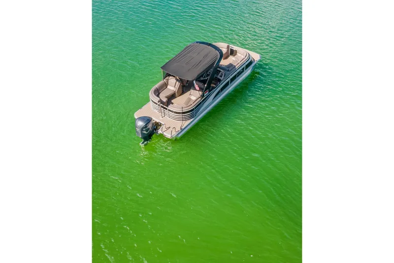 Slide: The Image of 2018 Bennington 25 QSR pontoon boat on vibrant green water, aerial view. - 12