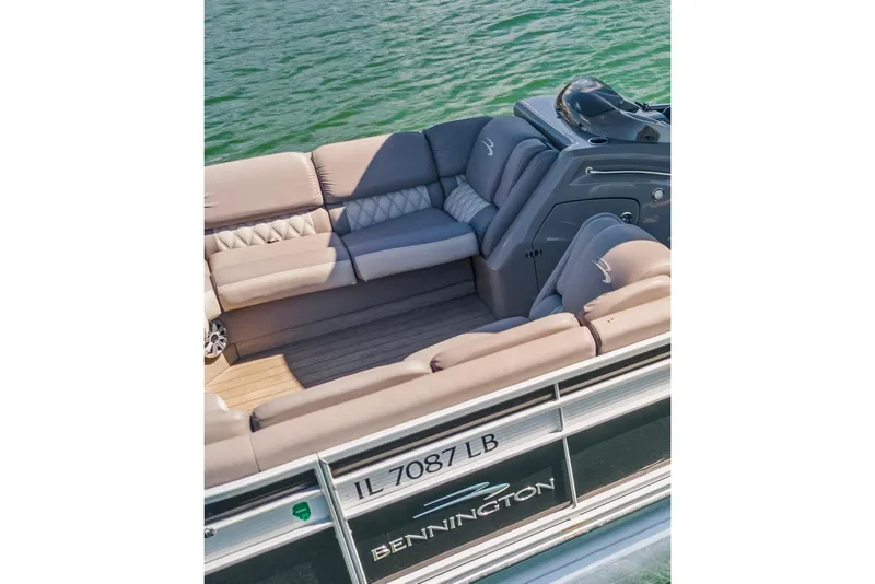 Slide: The Image of 2018 Bennington 25 QSR pontoon boat interior with plush seating on a lake. - 14