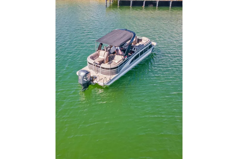 Slide: The Image of 2018 Bennington 25 QSR pontoon boat on calm green water. - 15
