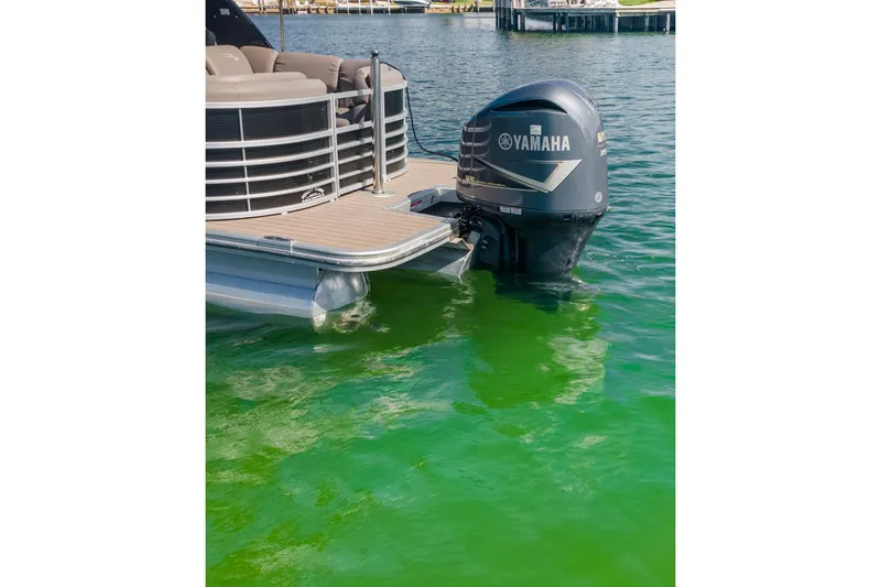 Slide: The Image of 2018 Bennington 25 QSR pontoon boat with Yamaha outboard motor on green water. - 16
