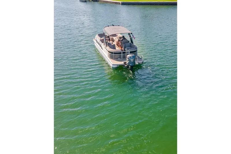 Slide: The Image of 2018 Bennington 25 QSR pontoon boat cruising on a sunny lake. - 4