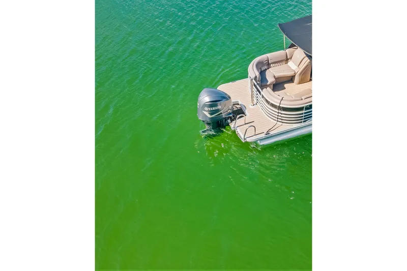 Slide: The Image of 2018 Bennington 25 QSR pontoon boat with Yamaha motor on vibrant green water. - 5