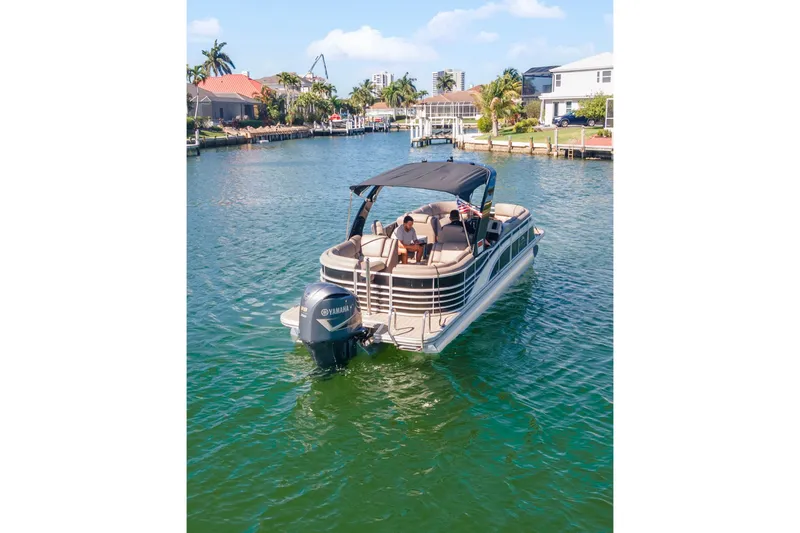Slide: The Image of 2018 Bennington 25 QSR pontoon boat cruising on a sunny waterfront. - 8