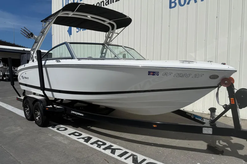 Slide: The Image of 2016 Cobalt 220 boat on trailer, parked outside a building. - 1