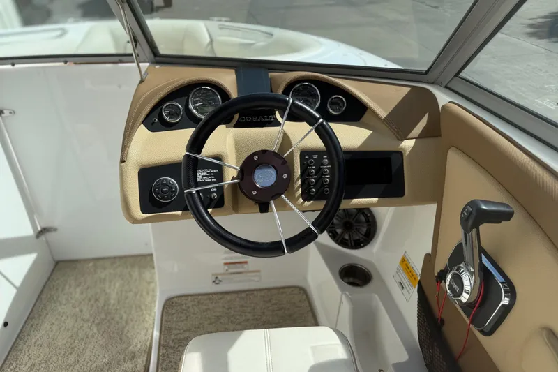 Slide: The Image of Interior view of a 2016 Cobalt 220 boat dashboard with steering wheel and controls. - 10