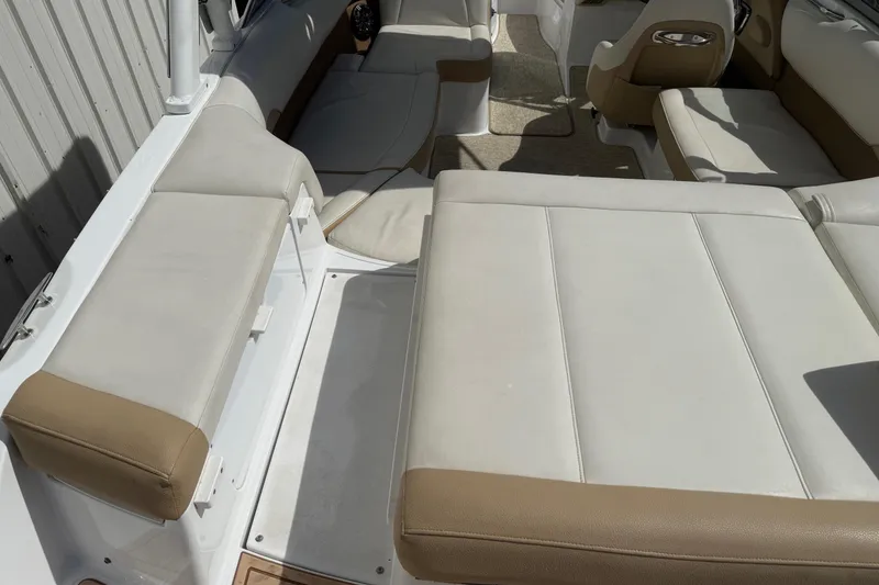 Slide: The Image of Interior seating of a 2016 Cobalt 220 boat with beige and white upholstery. - 12