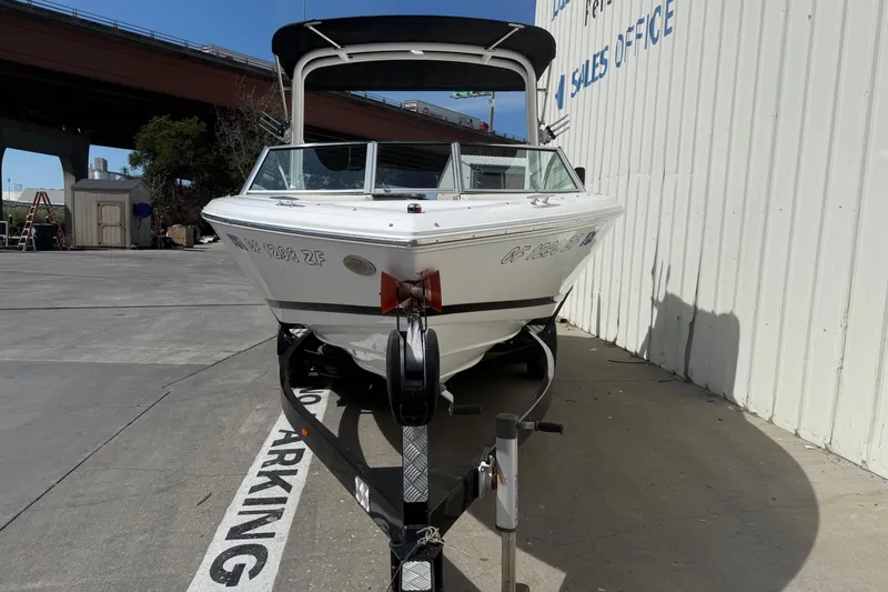 Slide: The Image of 2016 Cobalt 220 boat on trailer near sales office, under a bridge. - 2