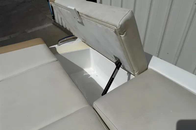 Slide: The Image of Open storage compartment on 2016 Cobalt 220 boat with cushioned seating. - 22