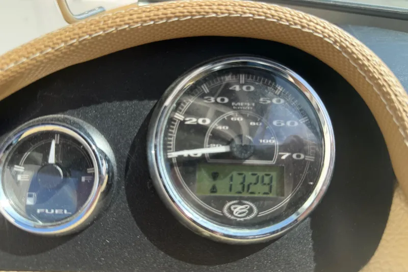 Slide: The Image of Close-up of 2016 Cobalt 220 boat speedometer and fuel gauge, displaying 132.9 hours. - 23