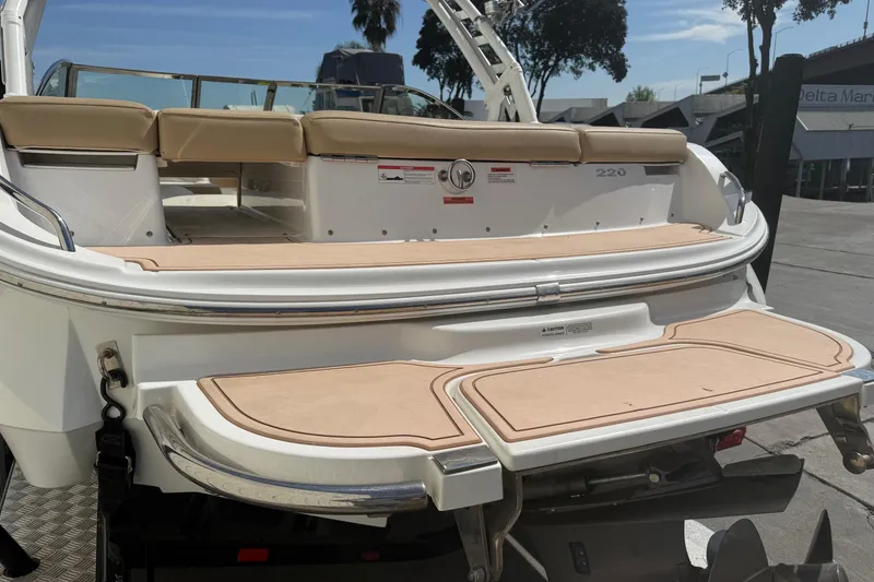 Slide: The Image of 2016 Cobalt 220 boat with beige seating and swim platform, docked outdoors. - 8