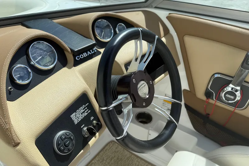 Slide: The Image of Steering wheel and dashboard of a 2016 Cobalt 220 boat, featuring gauges and controls. - 9
