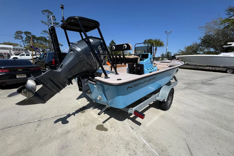 Slide: The Image of 2004 Kenner 21 VX boat with Yamaha outboard motor on trailer, parked outdoors. - 11