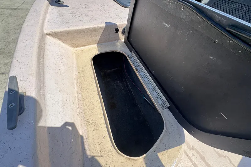 Slide: The Image of 2004 Kenner 21 VX boat storage compartment with open hatch, showing interior space. - 19