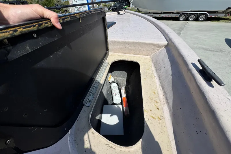 Slide: The Image of Open storage compartment on a 2004 Kenner 21 VX boat, containing various items. - 20