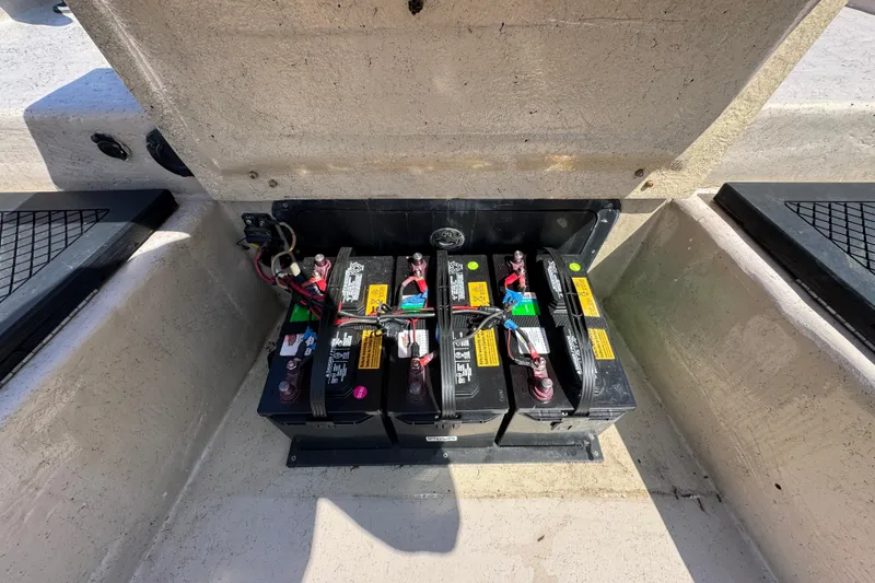 Slide: The Image of Battery compartment of a 2004 Kenner 21 VX boat, showing three connected batteries. - 21
