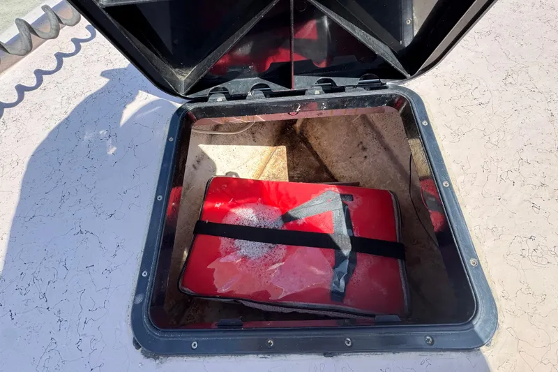 Slide: The Image of Open hatch on 2004 Kenner 21 VX boat with red life jacket inside. - 22